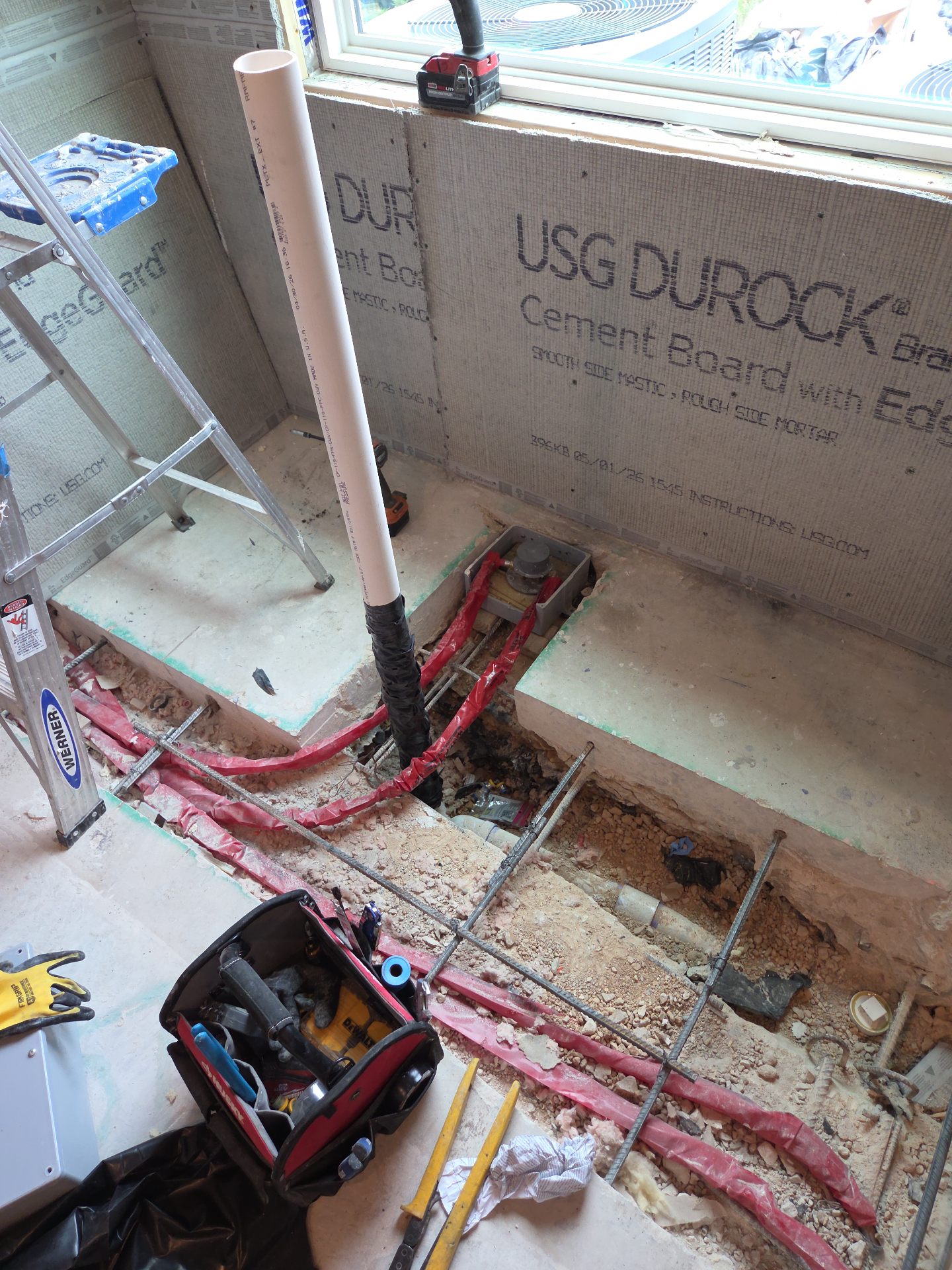 Under-slab pipe repair with exposed rebar and PVC