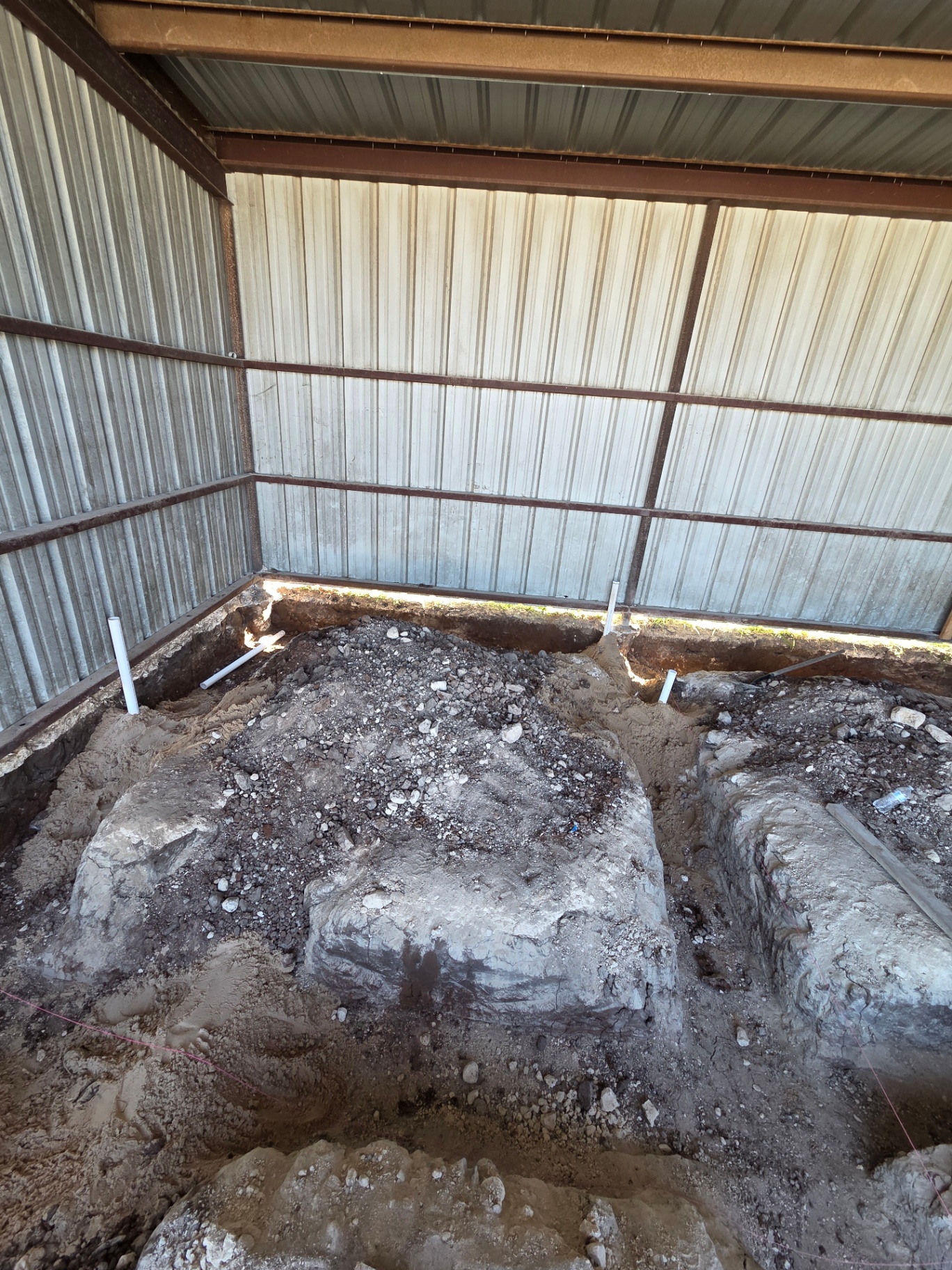 Commercial under-slab plumbing excavation inside a metal building